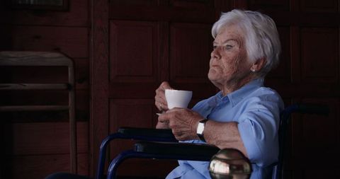 Senior Woman in Wheelchair Enjoying Coffee at Home
