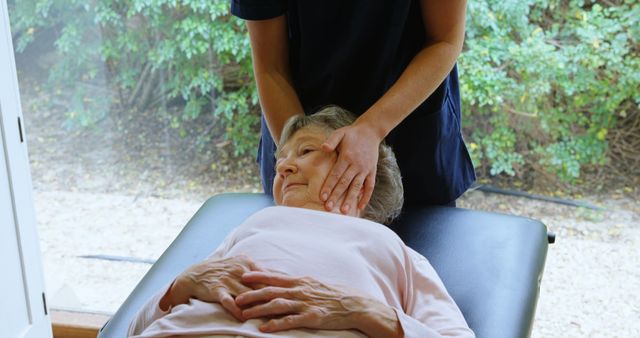 Elderly woman receiving chiropractic treatment, with therapist adjusting her neck. Ideal for health and wellness websites, chiropractic and massage therapy service promotions, and senior healthcare articles.