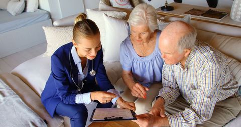 Senior Couple Consulting Doctor at Home Living Room Visit