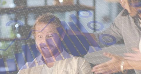 Bearded man collaborating on augmented data visualization with holographic charts, laptop