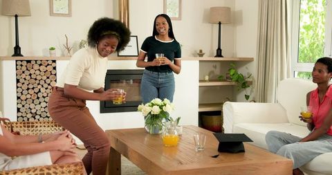 Friends Socializing in Cozy Living Room While Holding Drinks