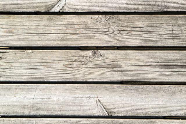 Weathered wooden planks ideal for use as a background or wallpaper. Perfect for design projects, presentations, websites, advertisements, and crafts. Adds a rustic, natural touch to various artistic and professional applications.