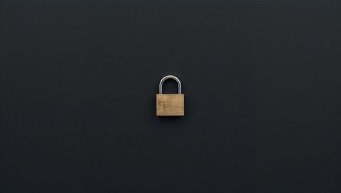 Brass Padlock Sitting on Dark Matte Surface Minimal Security Concept with Silver Shackle