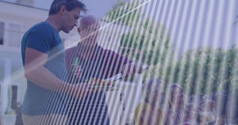 Man serving vegetable platter during outdoor family gathering