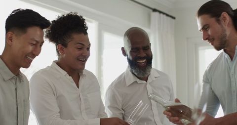 Joyful friends celebrating with champagne indoors