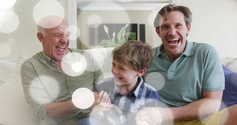 Laughing multigenerational family sharing playful tickle moment on cozy living room sofa