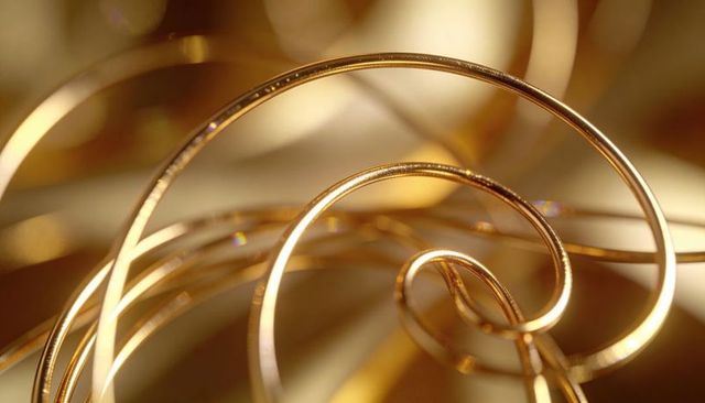 Shimmering intertwined gold wire spirals macro abstract luxury background