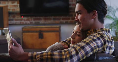 Happy Couple Using Tablet on Cozy Couch at Home