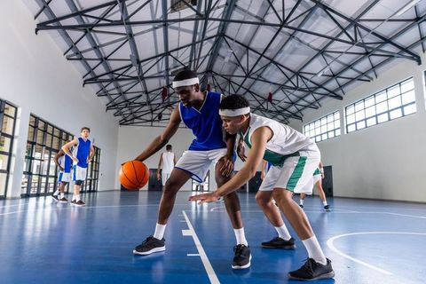 Teenagers Playing Intense Basketball on Indoor Court
