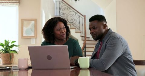 Joyful Couple Celebrating Online Achievement at Home