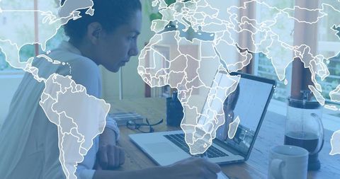 Working remotely and collaborating globally with laptop and world map overlay at home desk
