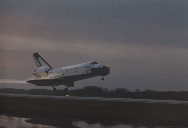 Space Shuttle Columbia lands at Kennedy Space Center’s Shuttle Landing Facility, Runway 33, at dawn following mission STS-80 on December 7, 1996. This landing marks the end of a record-setting 17-day, 16-hour space mission. Useful for articles on historical space missions, NASA achievements, aerospace engineering, and explorations. Ideal for publications emphasizing space exploration history and technological advancements.