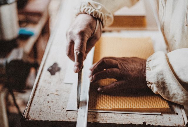 Close-up of experienced artisan using precision tools for detailed work on a yellow surface. Shows hands, tools, and workspace, emphasizing craftsmanship and attention to detail. Ideal for demonstrating skilled labor, DIY projects, and the art of handmade craftsmanship.