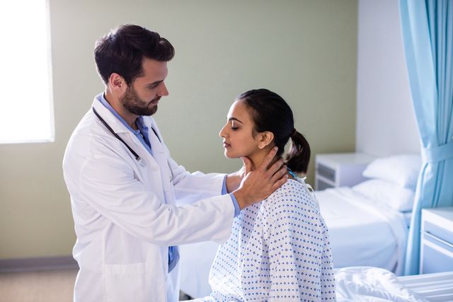 Male doctor examining female patient's neck in a hospital room. Useful for healthcare, medical consultation, patient care, and professional medical services themes.