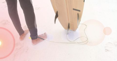 Surfer with vintage surfboard and artistic light flare