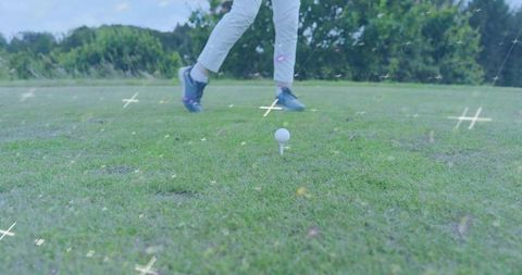 Low-Angle Senior Female Golfer Stepping from Tee with Golf Ball in Focus, White Trousers