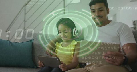 Father and daughter sharing tablet while daughter wearing headphones learning with futuristic ar hud