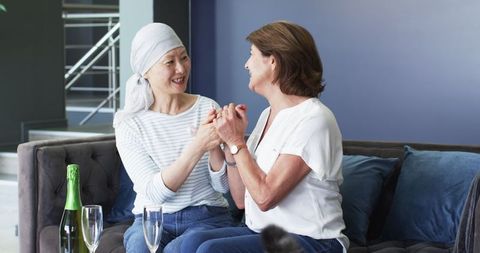 Senior Friends Celebrating With Champagne in Living Room