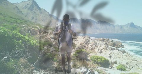 Male hiker navigating rocky coastal trail with backpack