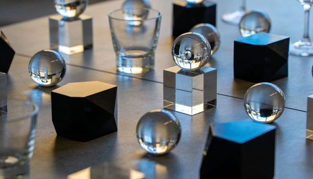 Crystal spheres reflecting studio light on acrylic cube pedestals with matte black blocks