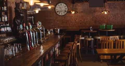Traditional Pub Interior with Wooden Bar and Clock - Download Free Stock Images Pikwizard.com