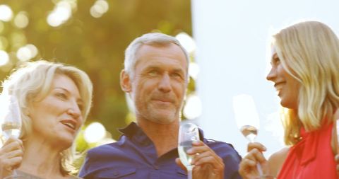 Caucasian Adults Toasting Outdoors in Warm Sunlight