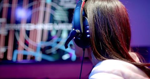 Teen Girl Immersed in Gaming with High-Tech Headset