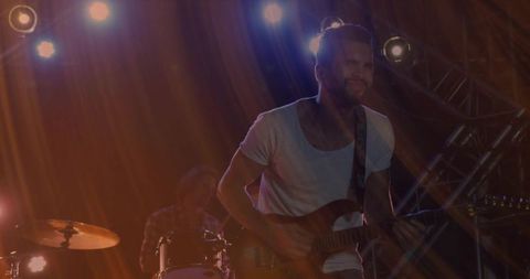 Energetic Guitarist Playing in Vibrant Concert Setting