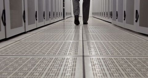 Business Professional Walking Through Data Center Hallway