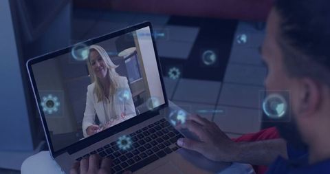 Man typing during remote video meeting with smiling businesswoman in white blazer