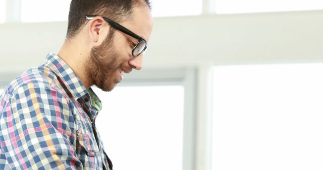 Smiling Man with Glasses Using Smartphone in Bright Room - Download Free Stock Images Pikwizard.com