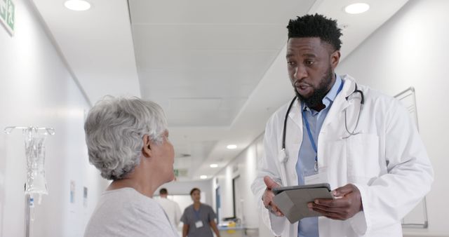 Doctor Discussing Medical Information with Elderly Patient in Hospital Hallway - Download Free Stock Images Pikwizard.com