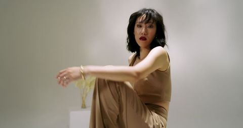 Elegantly dressed woman in minimalist studio setting