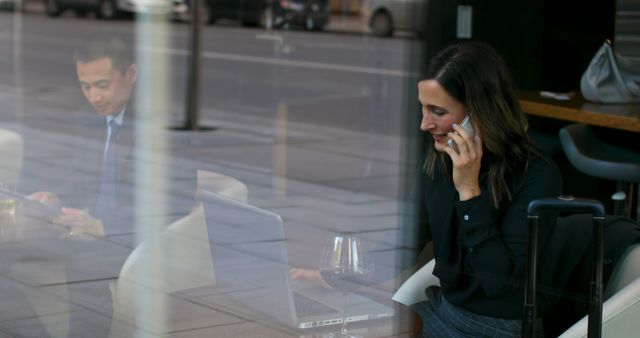 Businesswoman on Phone Working with Laptop in Office Building by Window - Download Free Stock Images Pikwizard.com