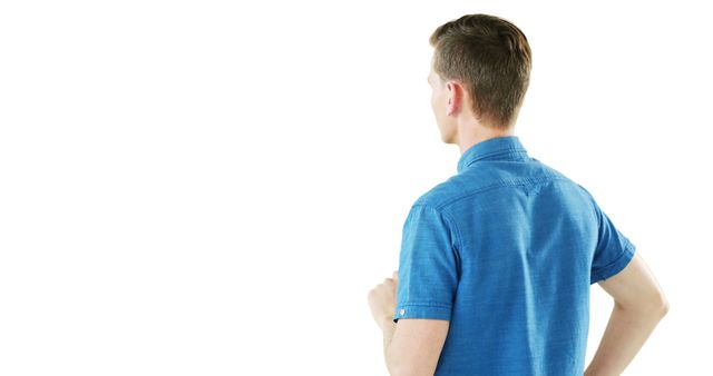Man in blue shirt looking away against white background. Perfect for illustrating concepts of contemplation, simplicity, or solitude. Suitable for advertising, marketing materials, and websites promoting casual fashion or lifestyle themes.