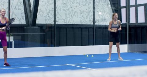 Female Padel Athletes Preparing on Contemporary Blue Court
