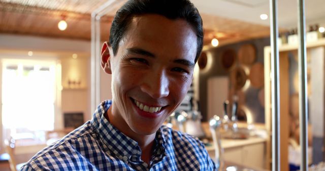 Smiling Young Man in Checkered Shirt Indoors Brightly Lit Room - Download Free Stock Images Pikwizard.com