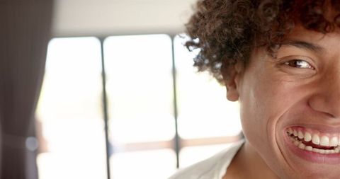 Portrait of Smiling Man with Curly Hair at Home