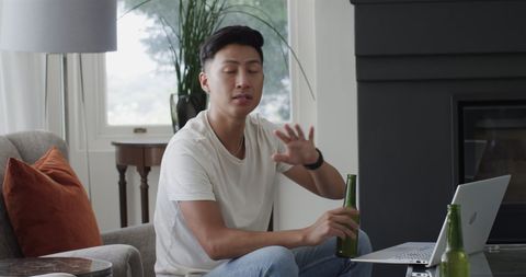 Man relaxing at home with beer and laptop