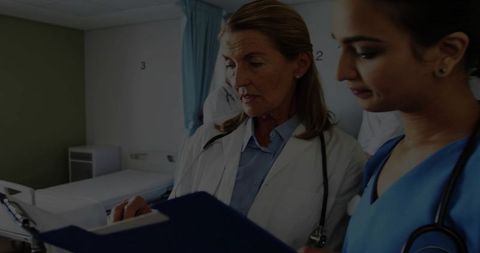 Senior Doctor Consulting with Medical Team in Hospital Ward