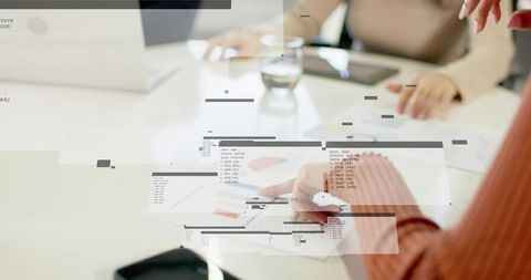 Pointing woman reviewing charts with pen and tablet during collaborative planning meeting