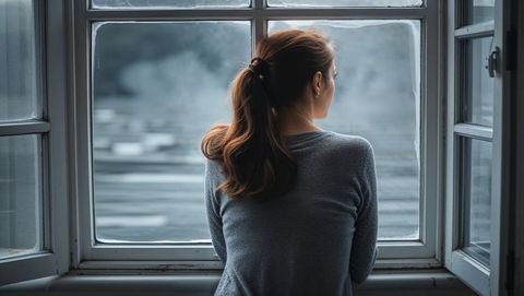 Contemplative Woman Gazing Out Window at Misty Lake View