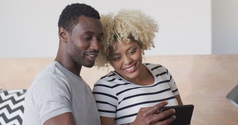 Expecting couple smiling at ultrasound photo together at home