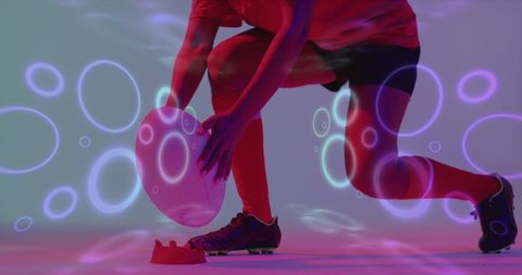 Female rugby player crouching with a dynamic neon pattern overlay on a luminous background. The sporty theme combined with vibrant neon effects suggests energy and movement. Ideal for sports advertising, athletic brand promotions, dynamic poster design, and visual communication campaigns emphasizing vitality and modern digital effects.