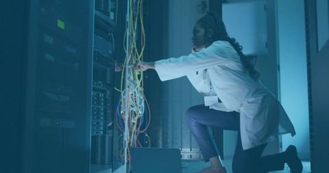Female IT Technician Optimizing Server in Data Center