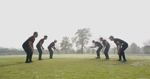 Male Athletes Facing Off Outdoors: Unity and Competition