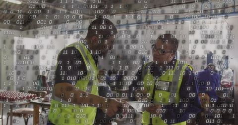 Workers reviewing digital checklist in aircraft hangar with binary code overlay