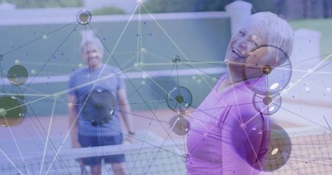 Joyful elderly woman playing tennis on a bright day