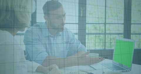 Business professionals reviewing financial analytics on laptop with green-screen overlay
