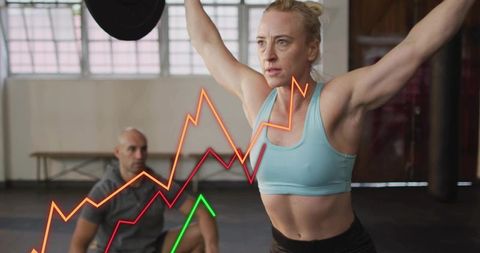 Female Athlete Lifting Barbell Overhead While Coach Spotting, Performance Graph Overlays